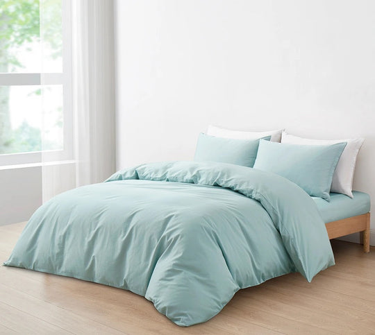 Bed dressed in a pale aqua Momomi anti-allergy duvet cover and pillow shams by a bright window
