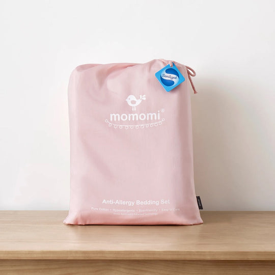 Pink Momomi anti-allergy bedding set in a drawstring bag with a Sanitized tag on a wooden shelf